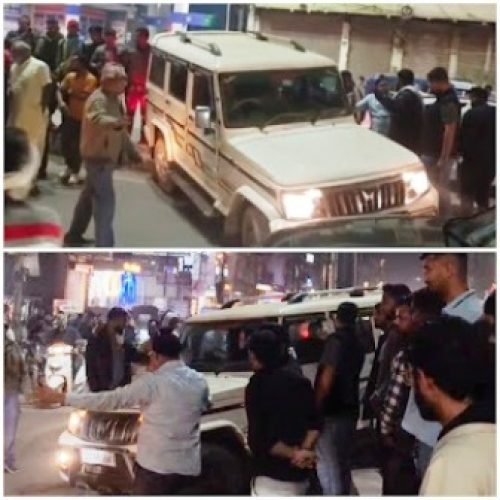घड़ी चौक पर हादसे के बाद बोलेरो वाहन डिवाइडर पर चढ़ा हुआ, मौके पर जुटी भीड़ और यातायात पुलिस।